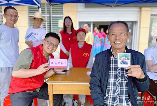 “溫情照相館”攤位上，前來照相的老人與志愿者開心地合影留念_副本.jpg